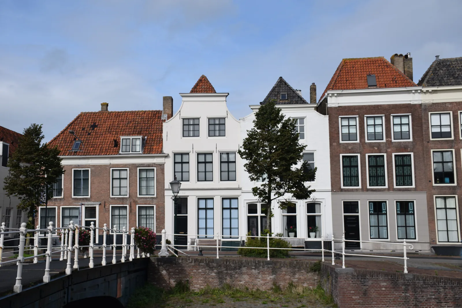 Karakteristieke oudere woningen met trapgevels aan een Nederlandse gracht